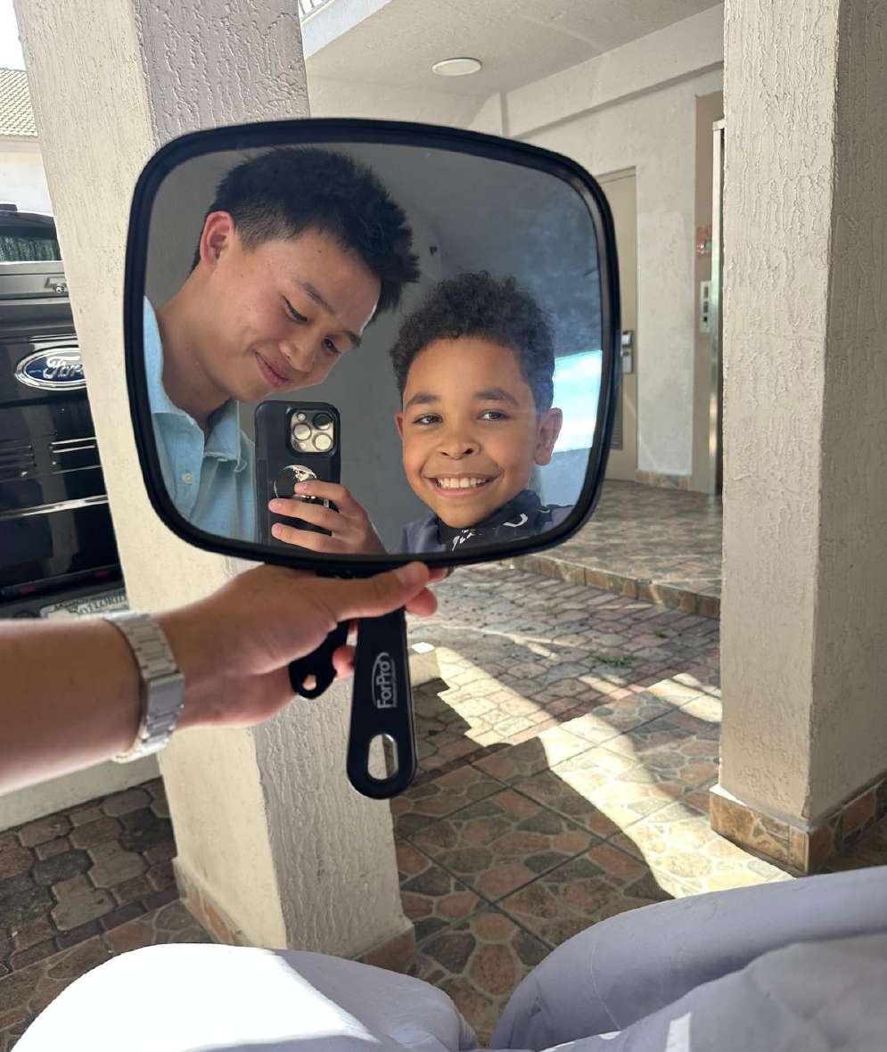 Showing a young client his new haircut in the mirror